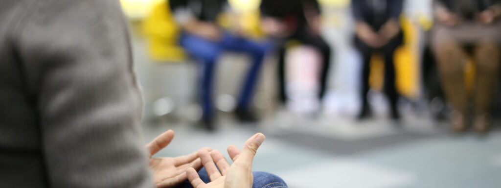 Behind-view of an individual gesturing during a group therapy session, highlighting Group Therapy in Bergen County, NJ.